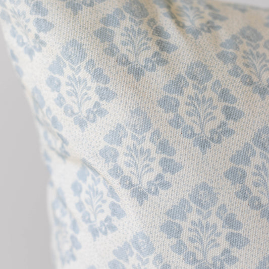 Blue and cream damask patterned pillow cover with woven fabric texture.