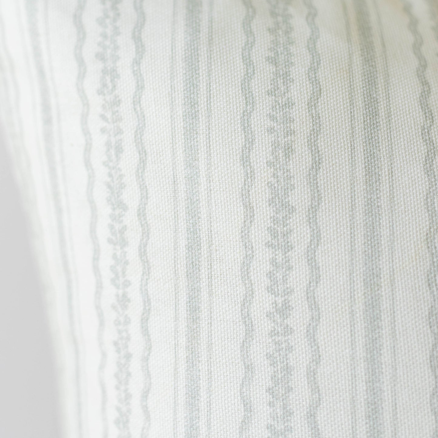 Cream and gray striped fabric with textured weave and decorative lace trim along the left edge.