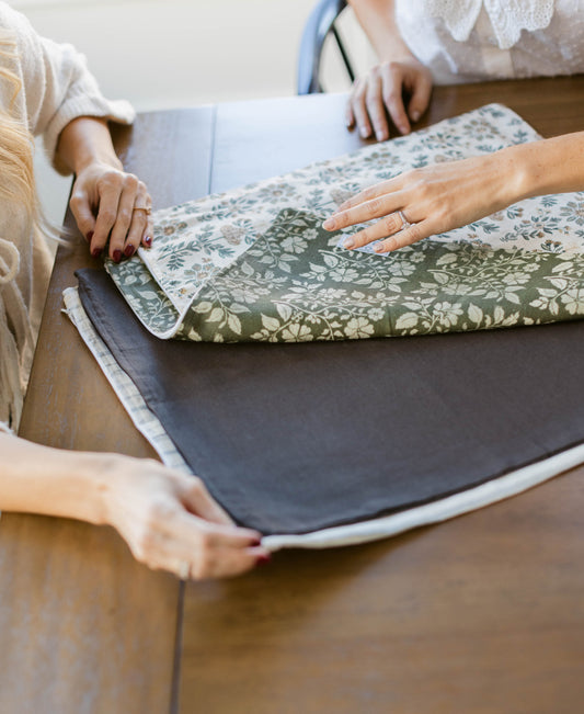 Linen pillow with green and white floral pattern, shown folded to display front design and gray backing.