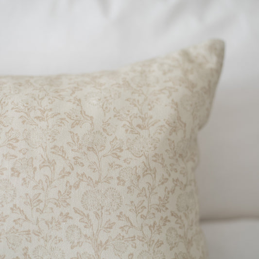 Cream decorative pillow with subtle damask pattern and floral texture throughout.