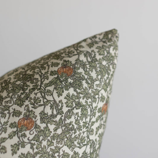 Rectangular pillow with cream background featuring green foliage and vining pattern with orange gourds throughout.
