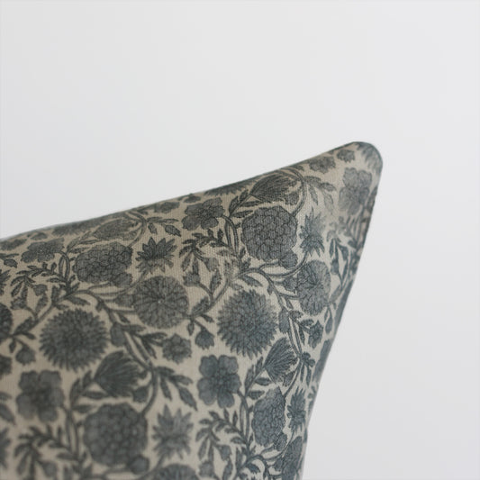 Blue and cream floral patterned pillow corner with botanical leaf design.