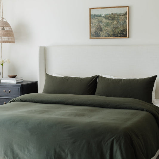 King-size bed dressed with olive-green duvet cover and matching pillowcases.