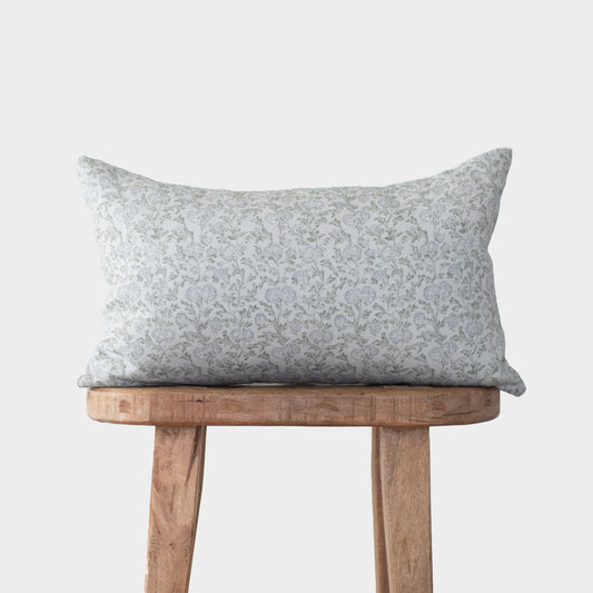 Gray and white floral linen pillow with small-scale botanical print displayed on wooden stool.