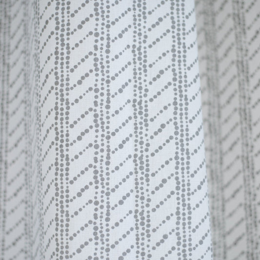 White shower curtain with gray diagonal dotted stripe pattern.