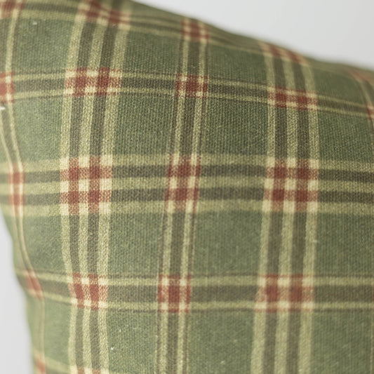 Green plaid fabric with burgundy and cream stripes in a woven tartan pattern.