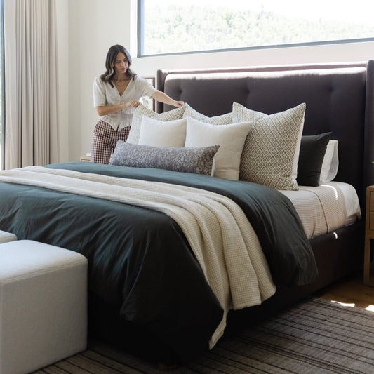 Gretta lumbar pillow with geometric pattern displayed on bed with coordinating bedding and decorative pillows.