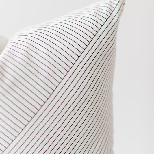 White pillow with thin dark gray pinstripes and ribbed texture.