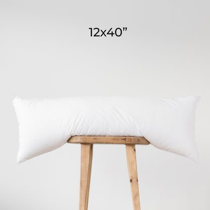 White rectangular faux down insert, 12x40 inches, displayed draped over wooden stool.