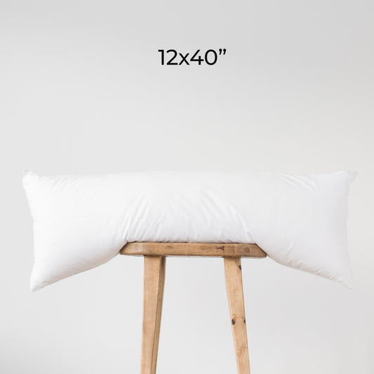 White rectangular faux down insert, 12x40 inches, displayed draped over wooden stool.