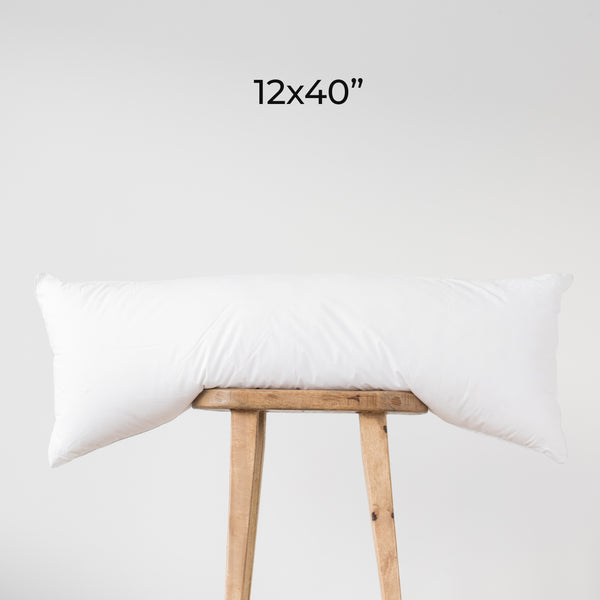 White rectangular faux down insert, 12x40 inches, displayed draped over wooden stool.