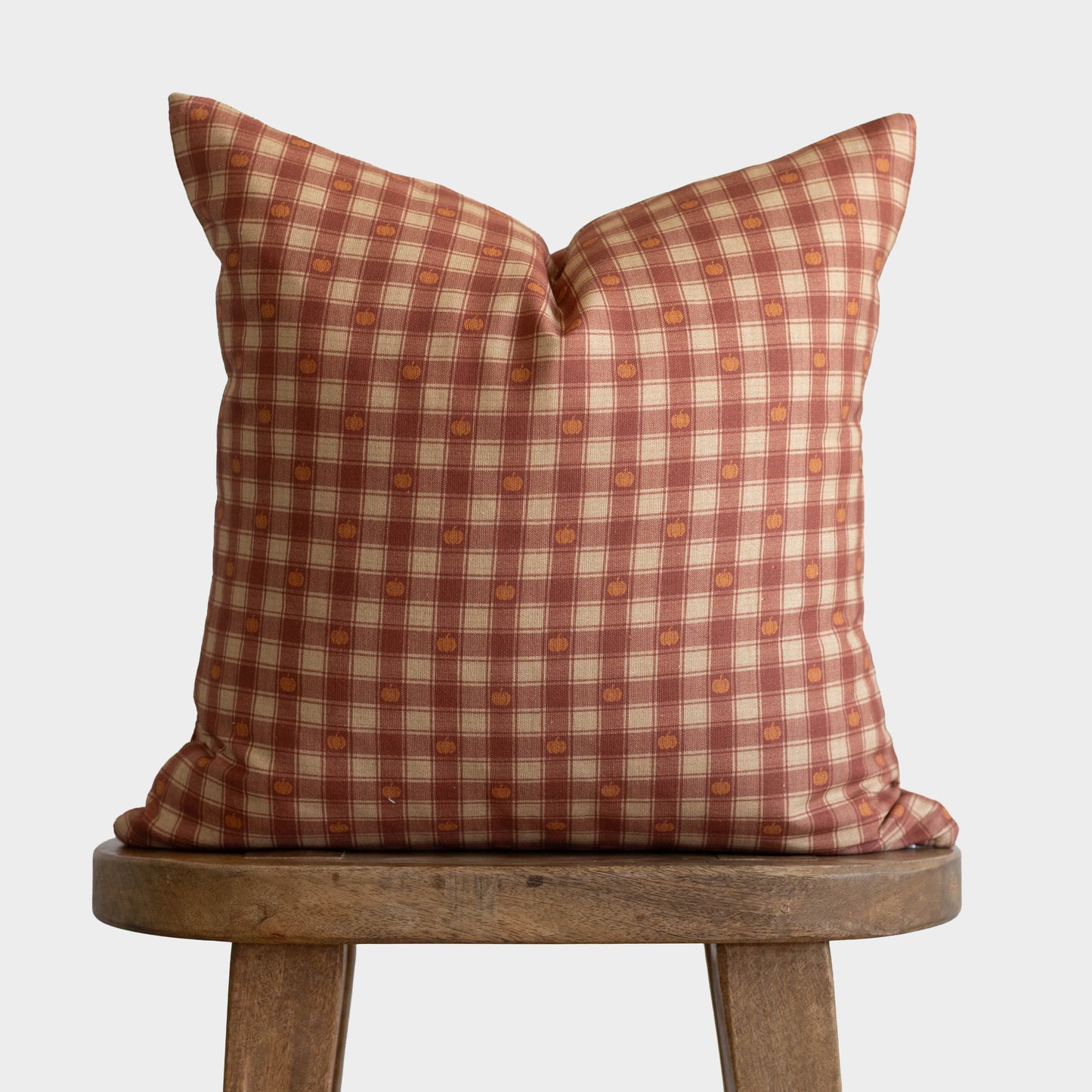 Pumpkin plaid throw pillow with red, cream, and orange checkered pattern with small pumpkin motifs.