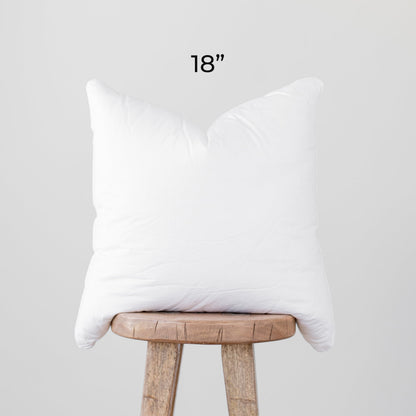 White faux down pillow insert, 18 inches, displayed on wooden stool.