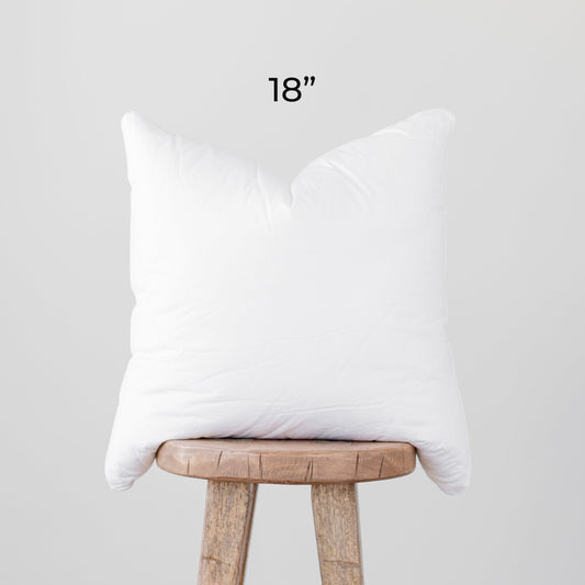 White faux down pillow insert, 18 inches, displayed on wooden stool.
