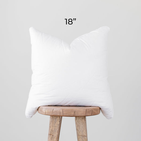 White faux down pillow insert, 18 inches, displayed on wooden stool.
