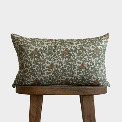 Rectangular pillow with green and cream botanical print featuring gourds and ivy vines with rust accents.