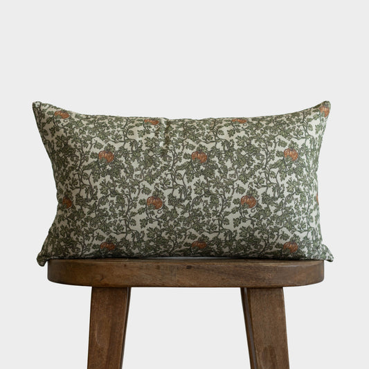 Rectangular pillow with green and cream botanical print featuring gourds and ivy vines with rust accents.