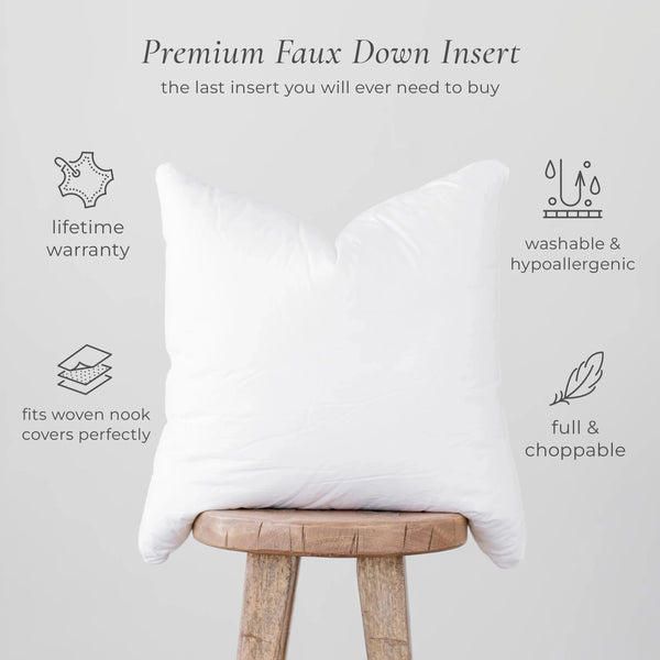 White rectangular faux down pillow insert displayed on wooden stool against gray background.