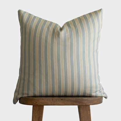 Crosby pillow with vertical gray and tan stripes on wooden stool.