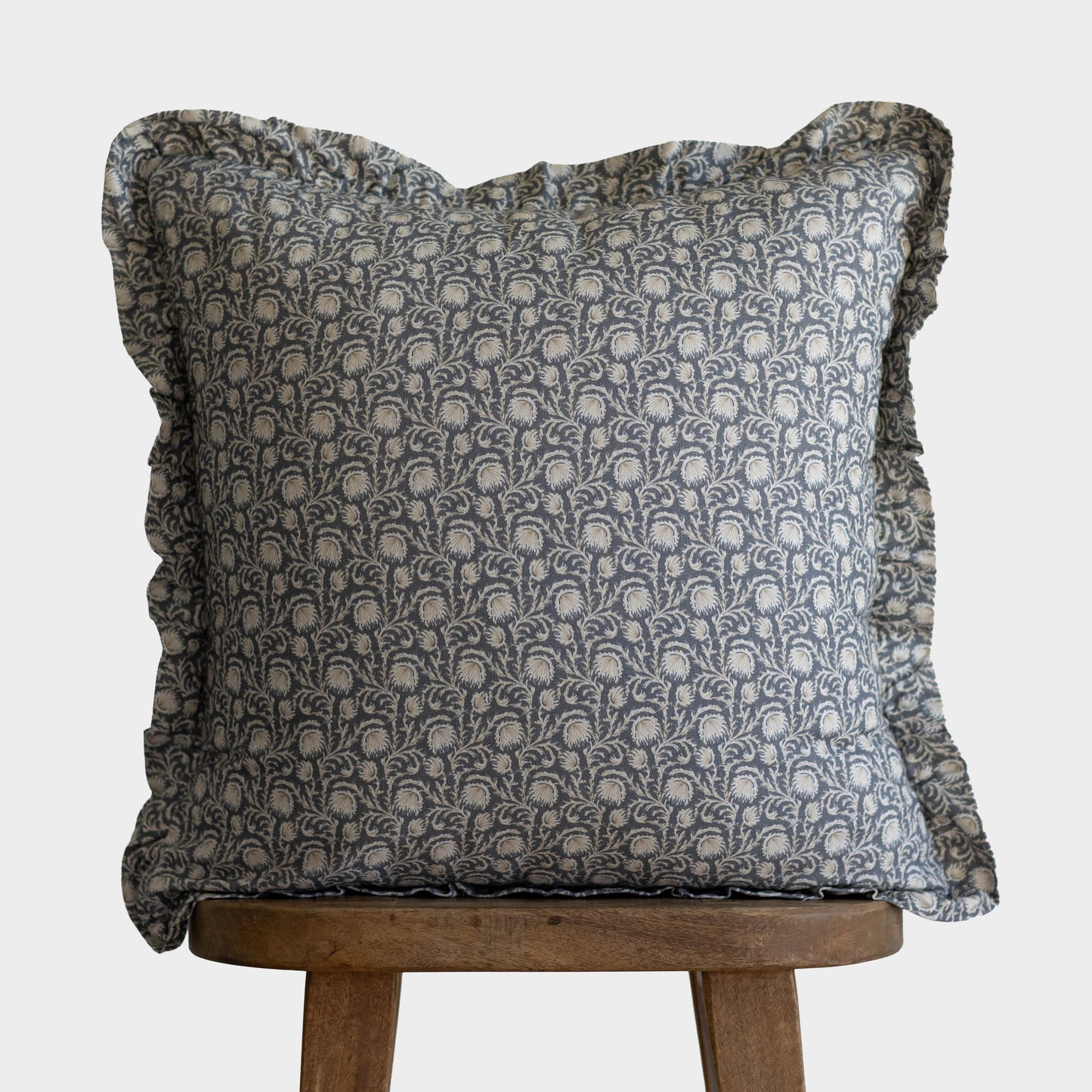 Decorative pillow with gray damask pattern and ruffled edges on all sides.