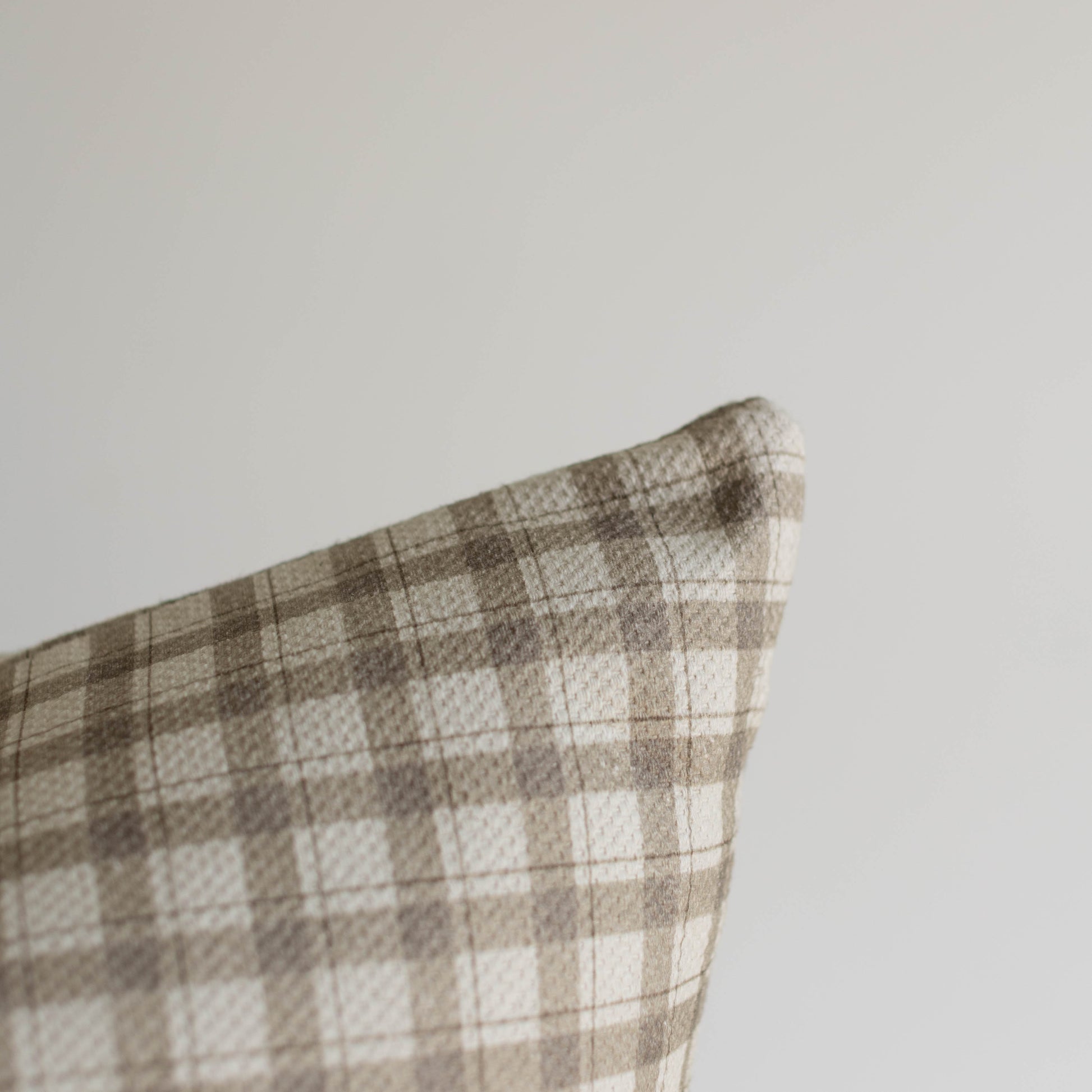 Beige and white gingham pattern cotton pillow with thick weave texture and folded corner detail.