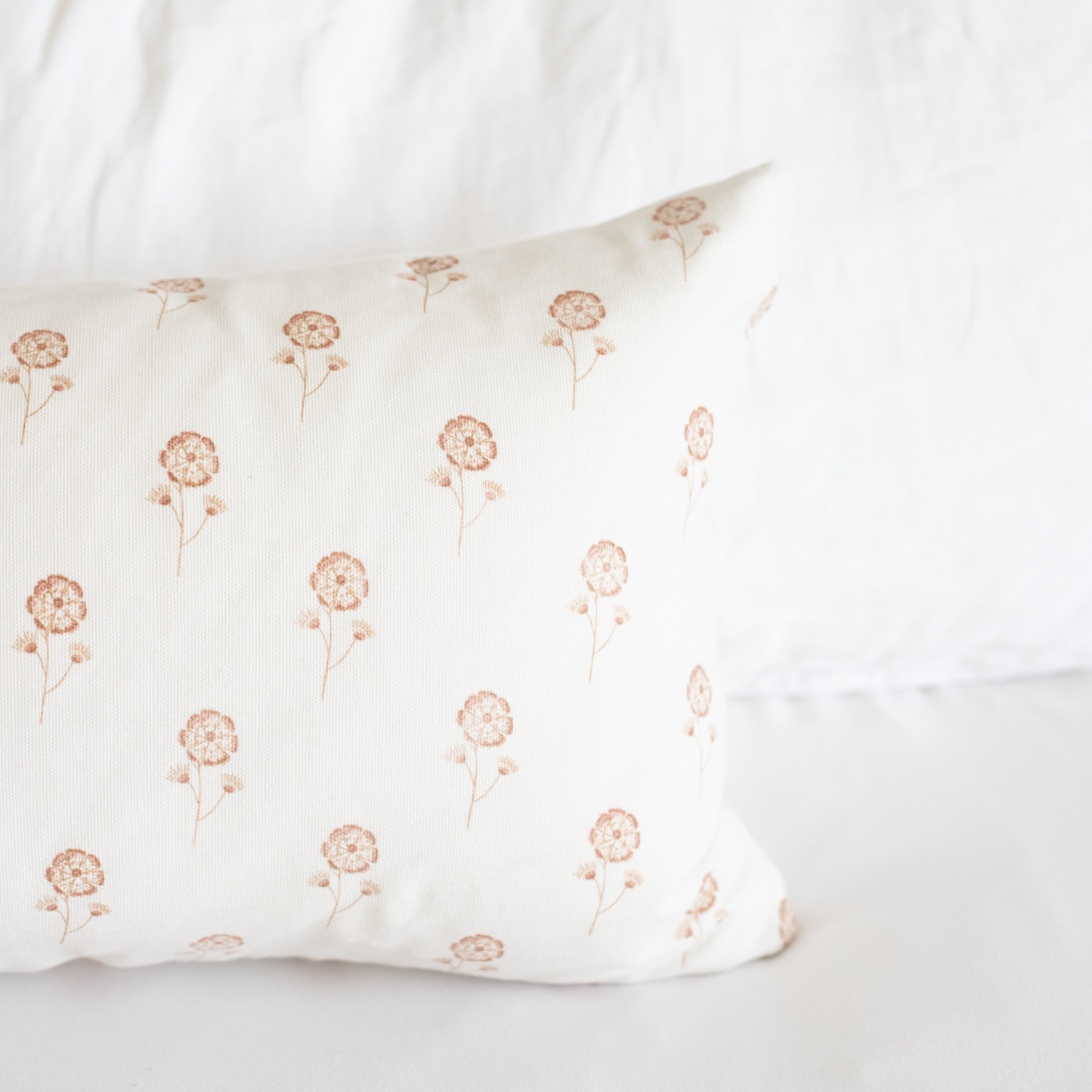 Cream pillow with scattered tan buttercup flower stems and blooms throughout.