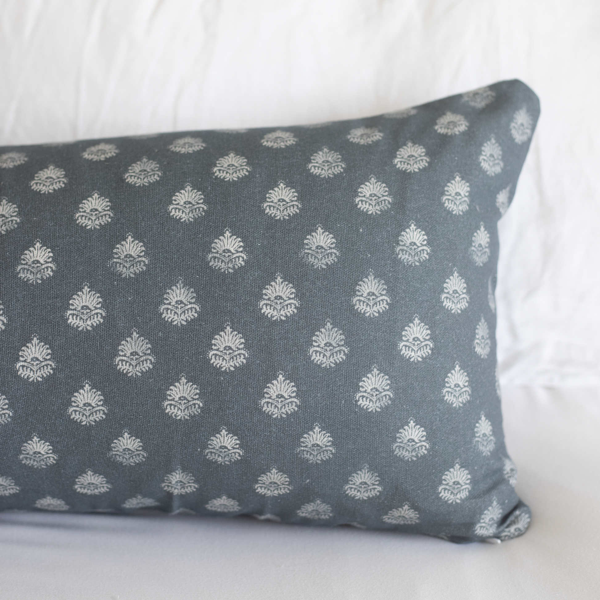 Blue-gray lumbar pillow with repeating cream damask pattern throughout.