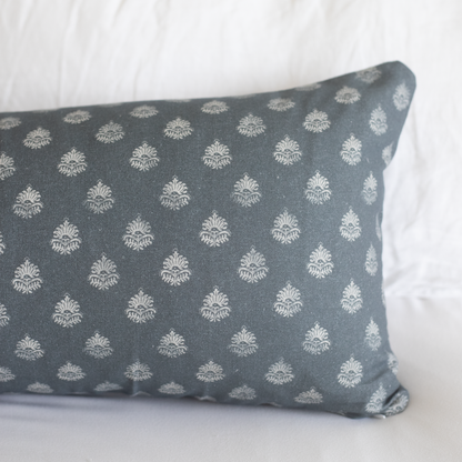 Blue-gray lumbar pillow with repeating cream damask pattern throughout.