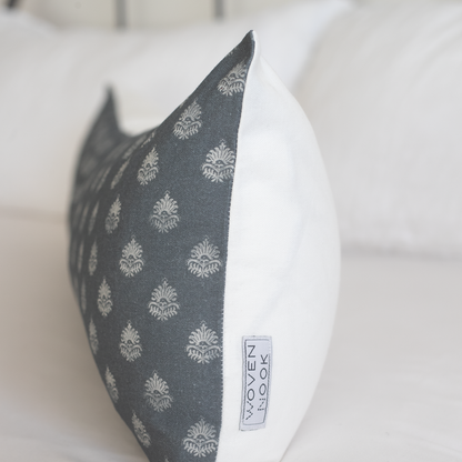 Rectangular lumbar pillow with dark gray damask pattern on front and white solid back, displayed at an angle.