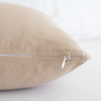Tan rectangular pillow with side zipper and white pull tab, shown at an angle.