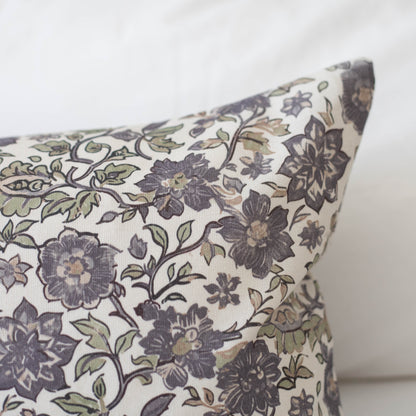 Cream pillow with dark blue and gray floral pattern featuring scrolling vines and layered flowers.