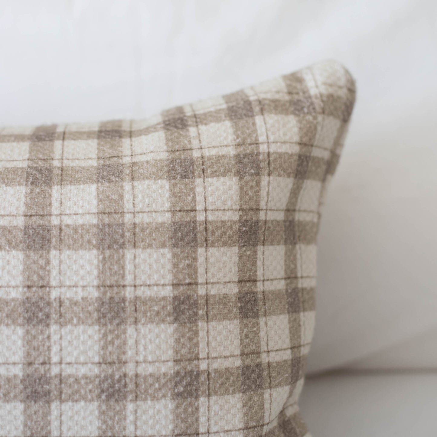 Beige and cream plaid cotton pillow with thick weave texture and rounded corner detail.