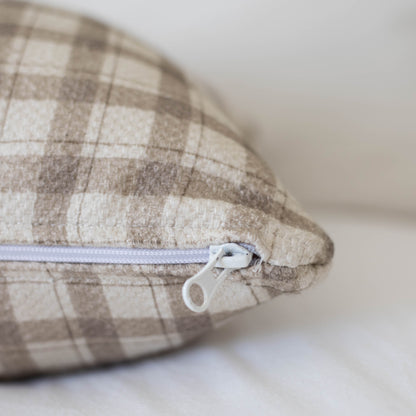 Beige and cream checkered cotton pillow with white zipper closure and thick weave texture.
