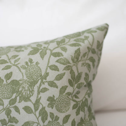 Cream pillow with sage green ivy and fruit botanical pattern on natural linen fabric.