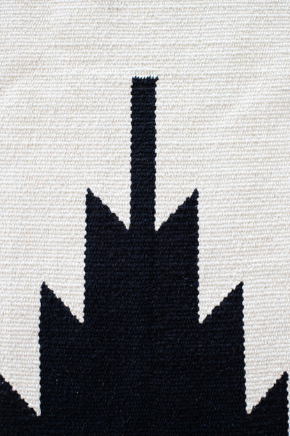Cream and black woven rug with saguaro cactus silhouette design.