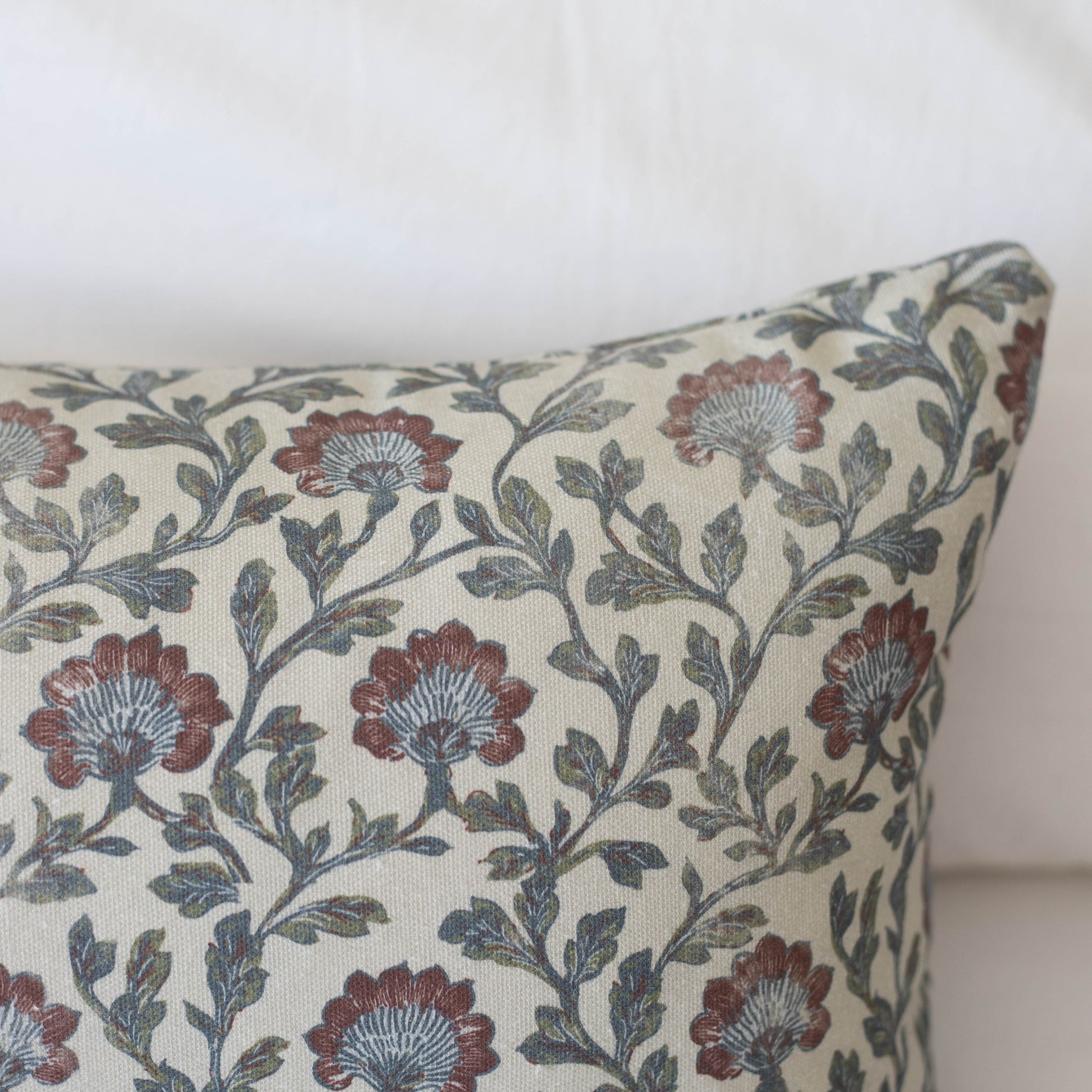 Cream pillow with burgundy flowers, blue-gray leaves, and curving vine pattern throughout.