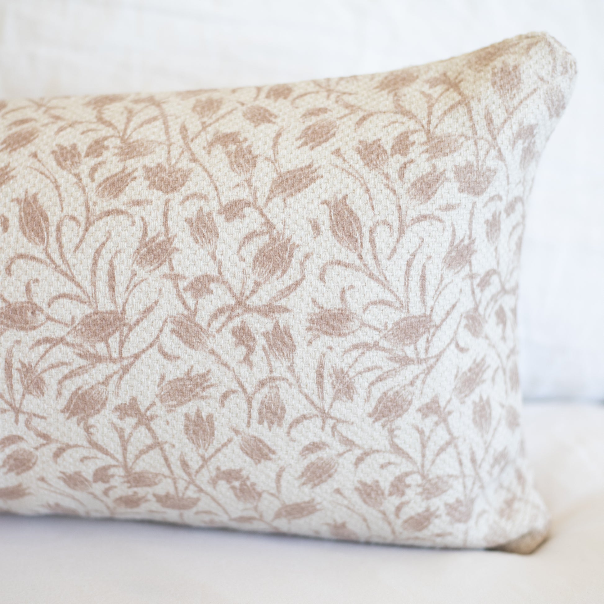 Beige and cream rectangular pillow with floral leaf pattern in thick woven fabric.