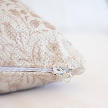 Beige and cream thick weave pillow cover with concealed zipper closure and textured fabric surface.