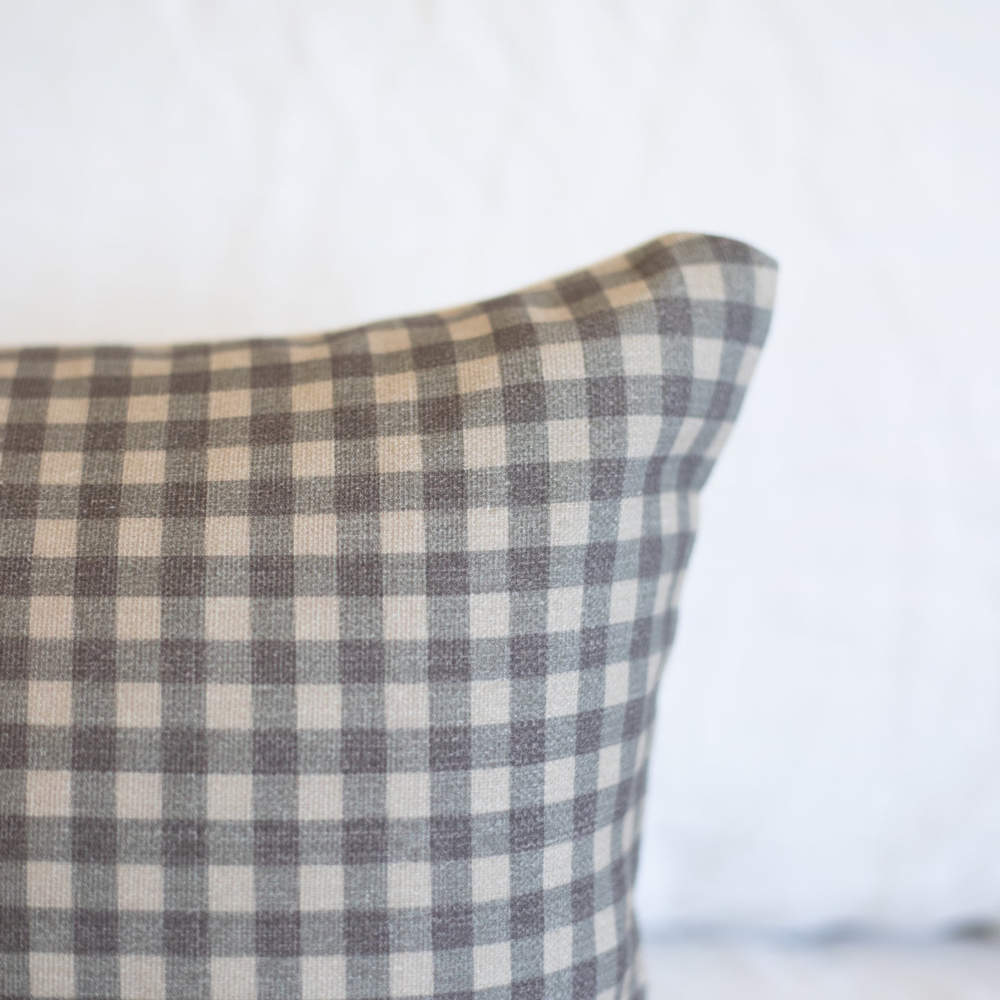Brown and cream gingham patterned lumbar pillow with woven texture.