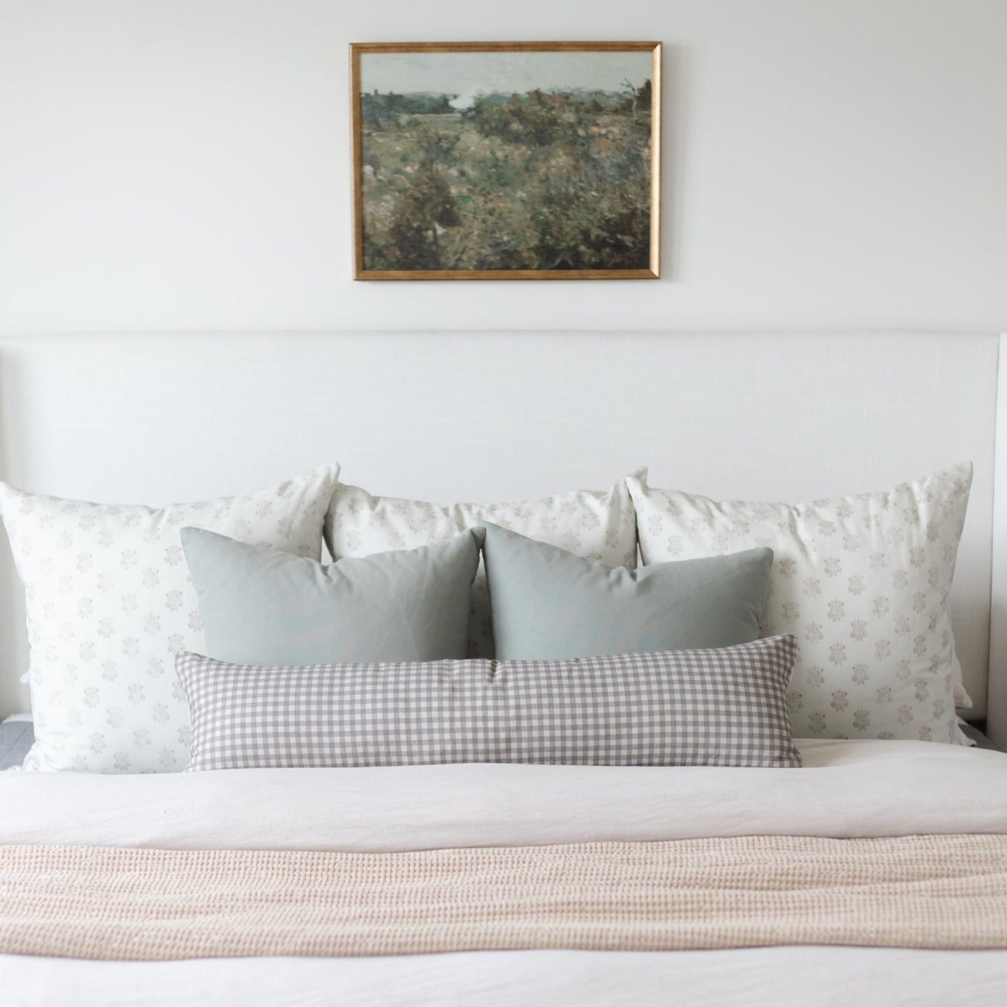 Brown and white gingham check lumbar pillow displayed on a bed with coordinating pillows.