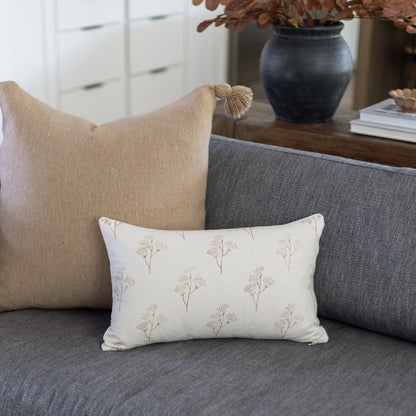 Rectangular lumbar pillow with cream background and repeating thistle flower pattern in taupe.