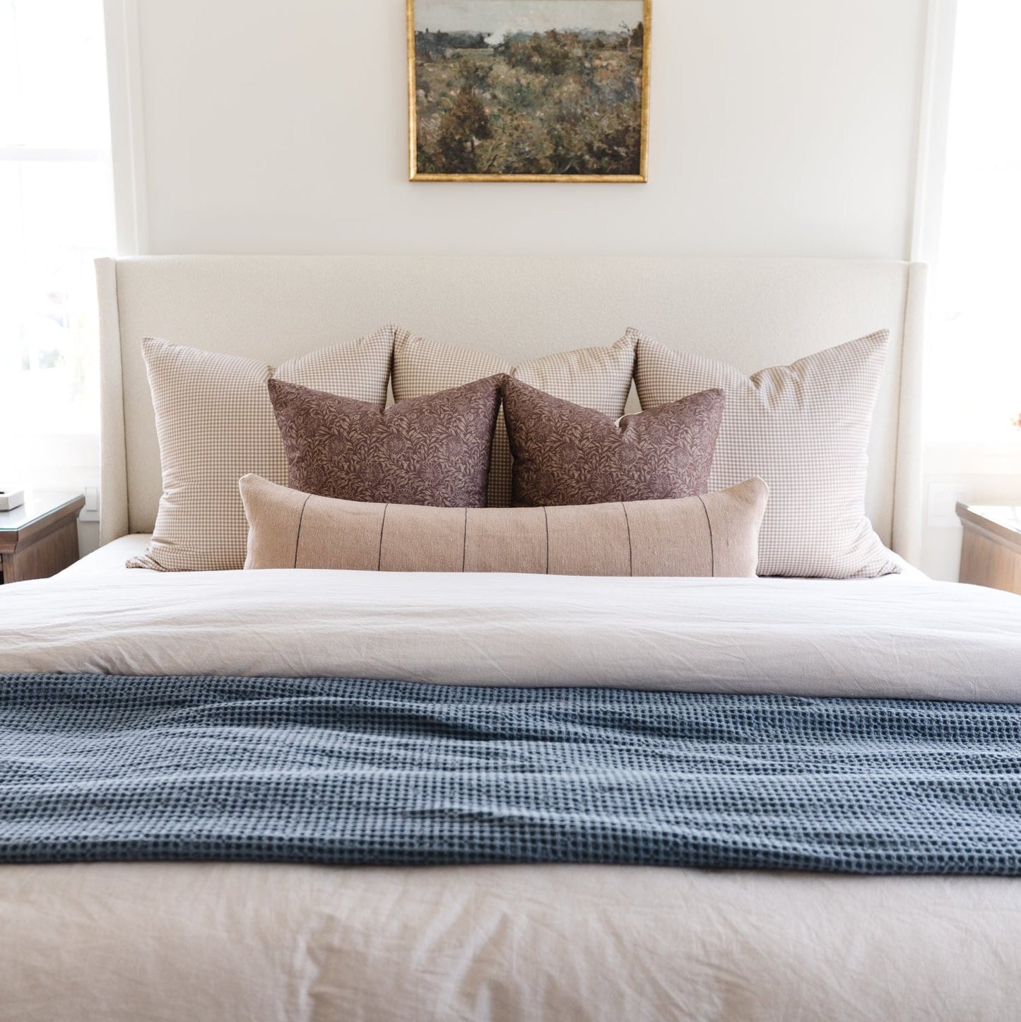Storm blue waffle-textured blanket draped across white bedding with decorative pillows.