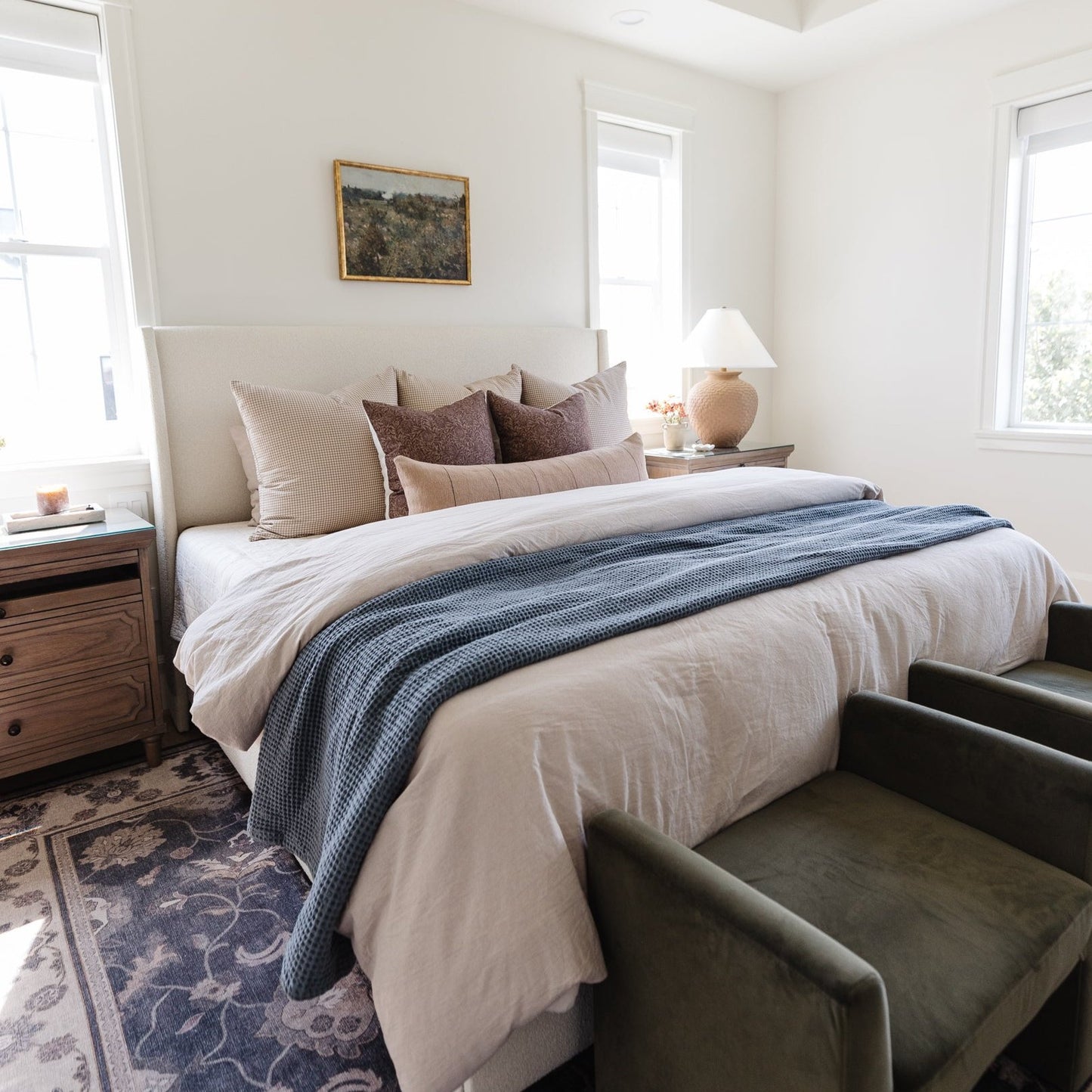 Storm blue waffle-textured blanket draped across a bed with white bedding and neutral pillows.
