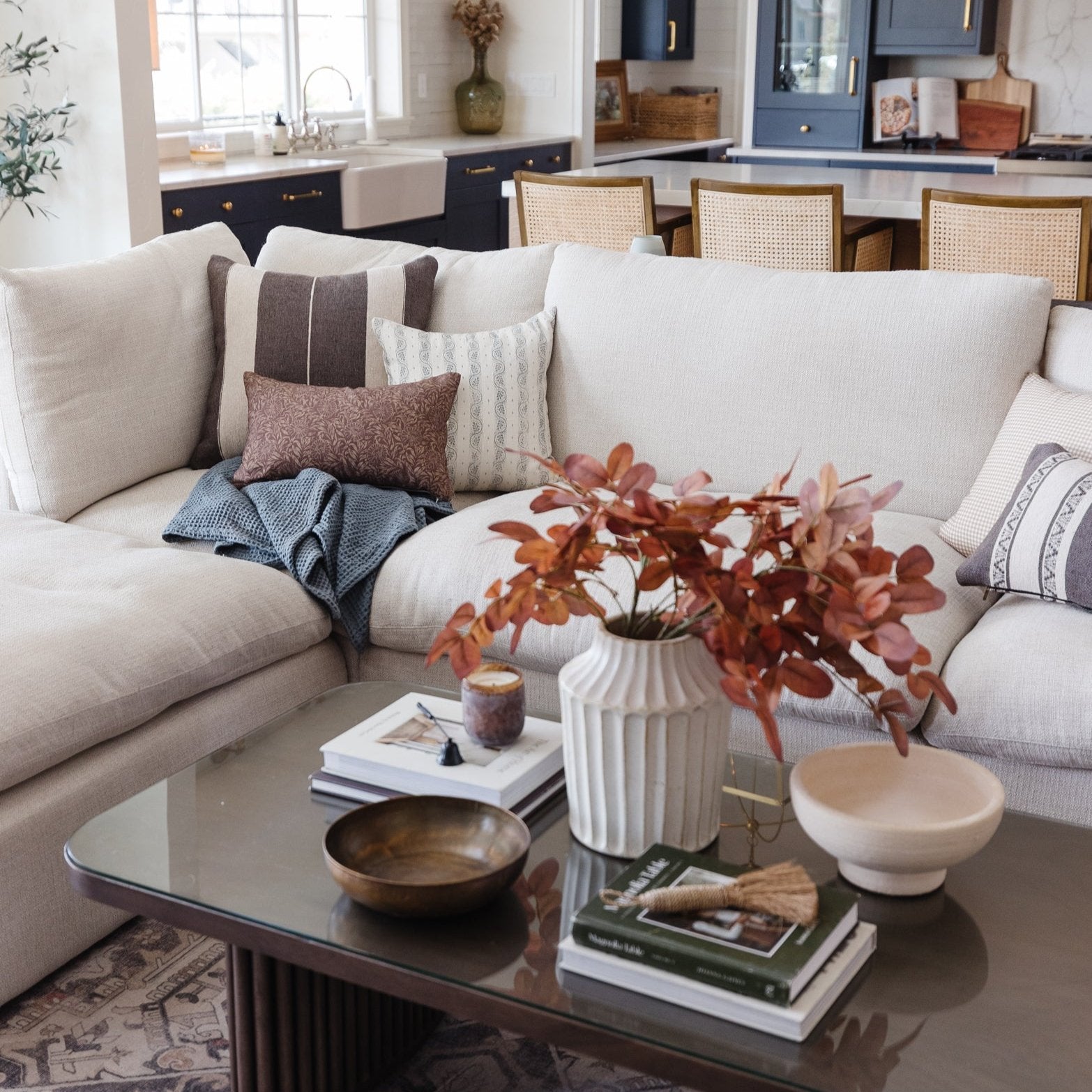 Beige lumbar pillow displayed on cream sectional sofa with coordinating cushions in living room setting.