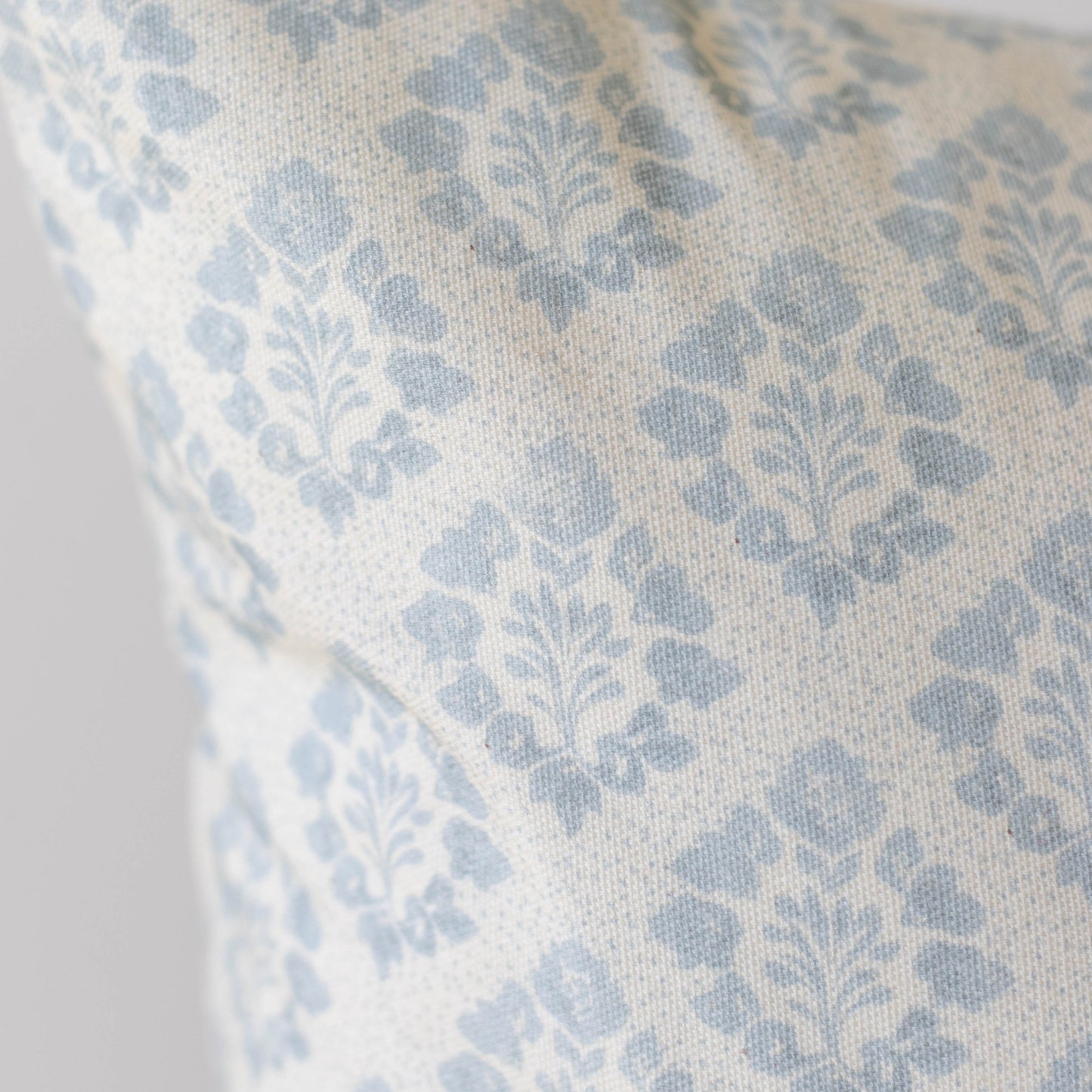 Blue and cream damask patterned pillow cover with woven fabric texture.