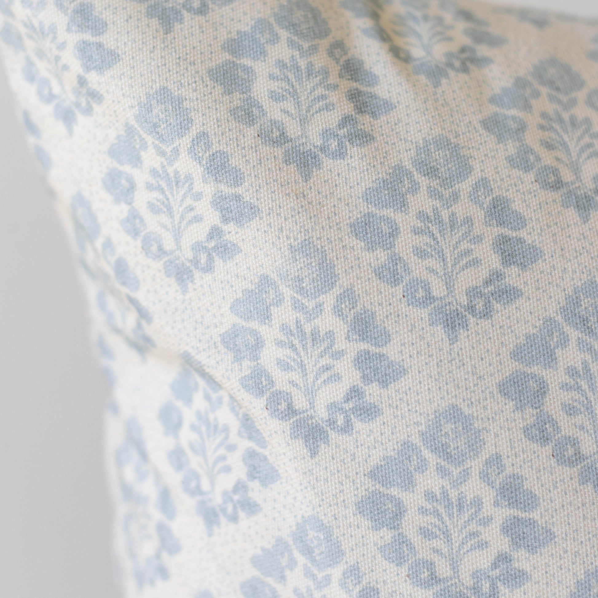 Blue and cream damask patterned pillow cover with woven fabric texture.