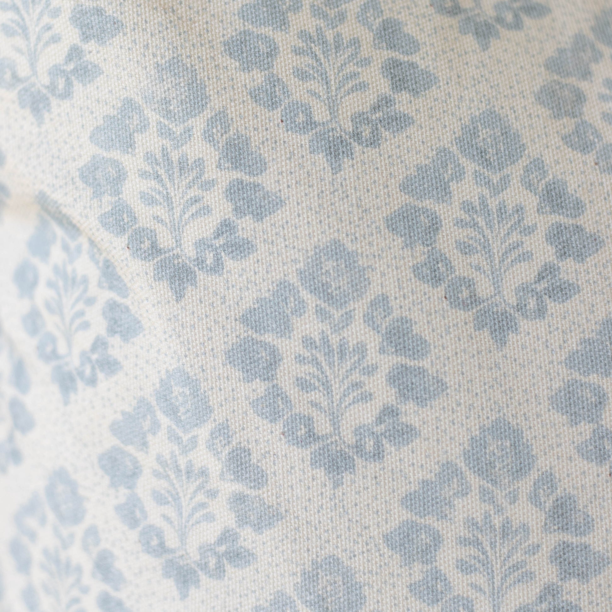 Blue and cream damask patterned pillow cover with woven texture.