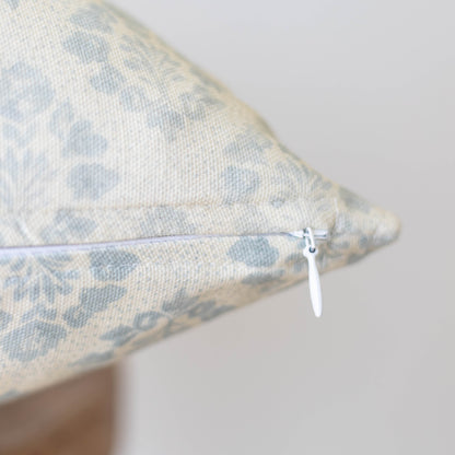 Cream and blue leopard print pillow with white zipper closure detail visible on seam.
