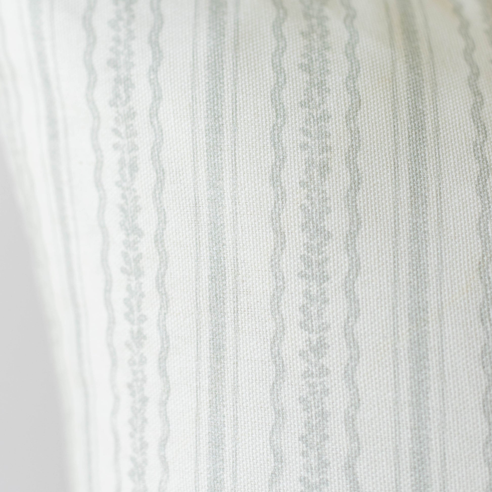 Cream and gray striped fabric with textured weave and decorative lace trim along the left edge.