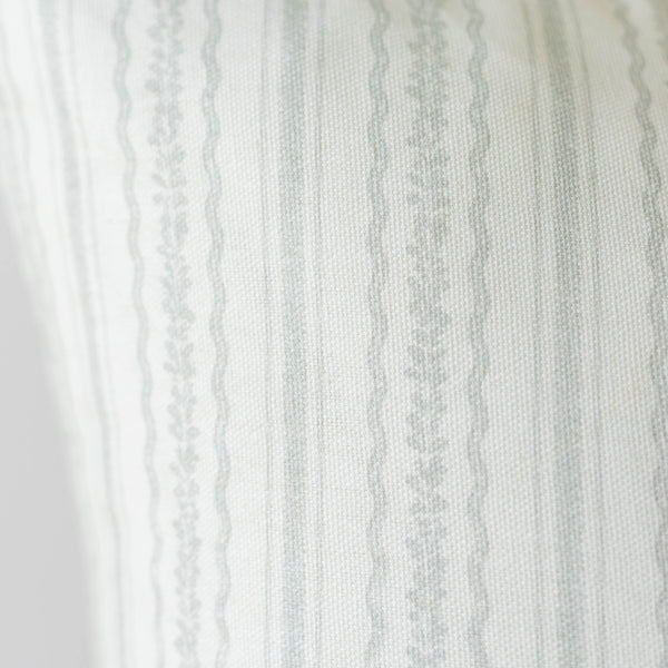 Cream and gray striped fabric with textured weave and decorative lace trim along the left edge.